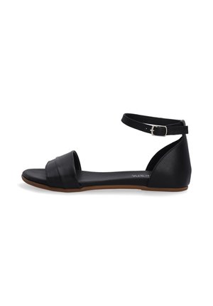 Black leather sandal with an ankle strap, featuring a wide front band and a flat sole. Smooth texture and minimalistic design.
