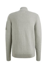 Lichtgrijze geribde pullovertrui met een hoge kraag. Heeft een textuur gebreide stof en een patch op de linkermouw. Lange mouwen met geribde manchetten.