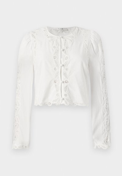 Blusa bianca corta con maniche lunghe, dettagli in pizzo e chiusura a bottoni sul davanti. Tessuto testurizzato con orlo a scallope e accenti ricamati.