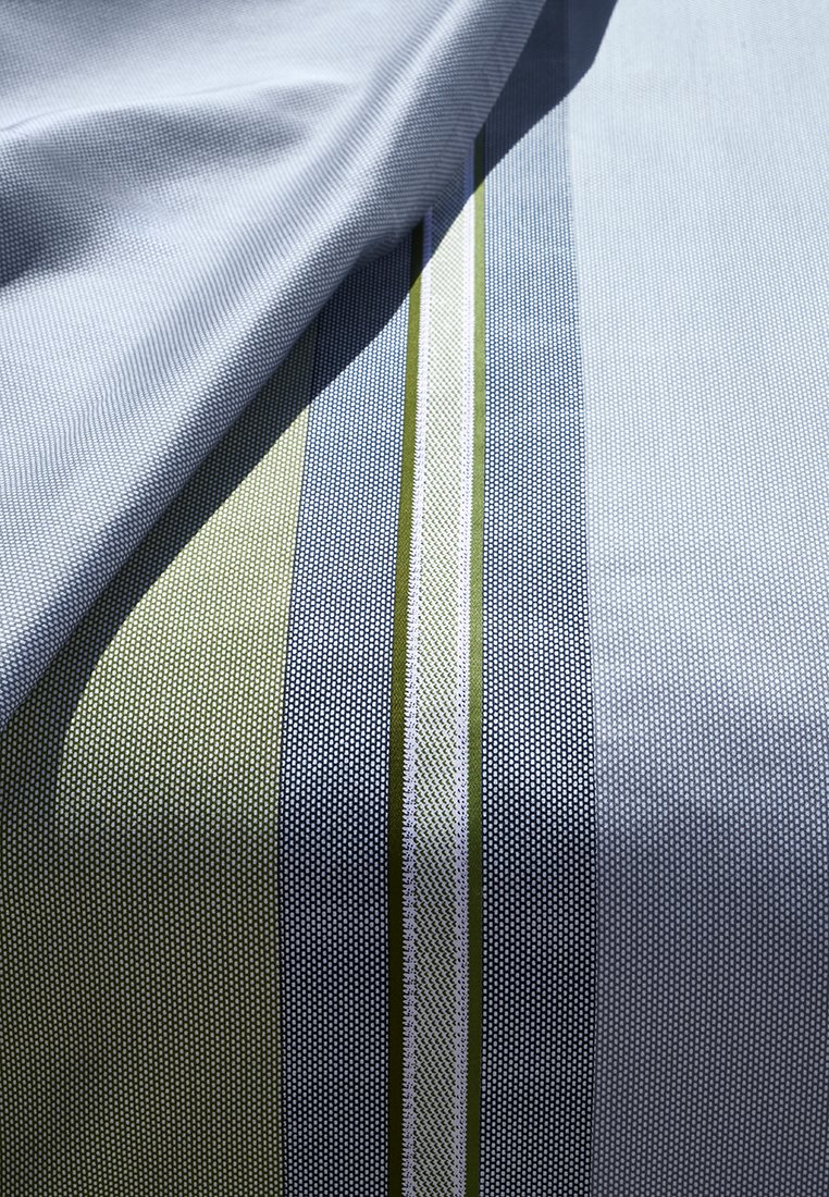 Tissu avec un motif texturé présentant des rayures bleu et vert, entrecoupées de fines lignes blanches sur un fond bleu clair.