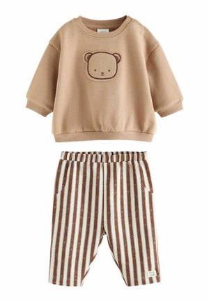 Beiges Babyoberteil mit langen Ärmeln und einem Bärengesicht auf der Vorderseite sowie braune und weiße vertikal gestreifte Hosen mit elastischem Bund.