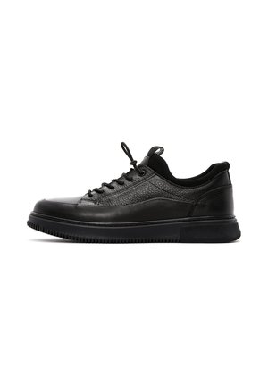 Black leather sneakers with textured upper, round toe, lace closure, and cushioned sole. Features a smooth black rubber outsole.