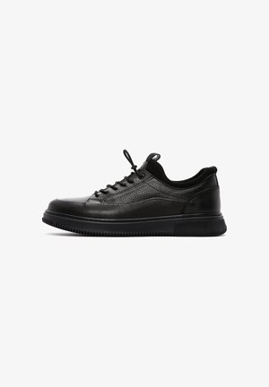Sneakers neri in pelle con tomaia testurizzata, punta rotonda, allacciatura e suola imbottita. Presentano una suola esterna in gomma nera liscia.