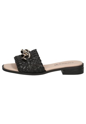 Sandale en cuir tressé noir avec une semelle plate, dotée d'un accent décoratif en chaîne dorée sur le dessus. Semelle intérieure beige lisse et design minimaliste.