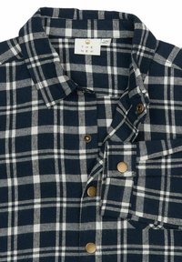 Camisa de cuadros en azul y blanco, con un diseño de botones, un cuello clásico y botones de bronce. Confeccionada en una tela suave con un acabado texturizado.