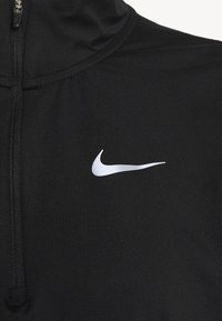 Black pullover with a zip neckline, made of smooth fabric. Features a white Nike swoosh logo on the right side.