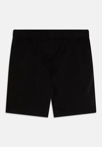 Mustat puuvillashortit, joissa on joustava vyötärö. Yksinkertainen muotoilu, reiden puoliväliin asti ulottuva pituus, sileä rakenne, eikä lisäkuvioita tai koristeita.