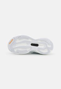 Sport shoe outsole featuring a textured white rubber surface, prominent grooves, and a black insert with orange accent. Designed for traction.