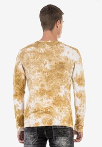 Langarmshirt mit einem Batikmuster in Brauntönen und Weiß, aus weichem Stoff mit lockerer Passform und rundem Ausschnitt.