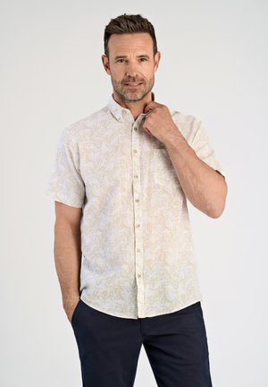 Korte mouwen overhemd in lichtbeige met een subtiel bloemenpatroon, voorzien van een borstzak en een ronde zoom, gecombineerd met marineblauwe broeken.