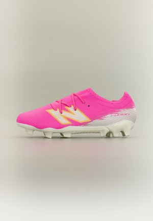 Crampon de football rose vif avec semelle blanche, logo "N" blanc et jaune sur le côté, et dégradé blanc avec le texte "Furon" près du talon.