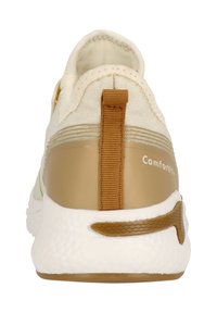 Vaaleanbeige urheilukengät, joissa on teksturoitu kangaspäällinen, kultainen korko-osa ja valkoinen pehmustettu pohja. Takana on vetoketju.