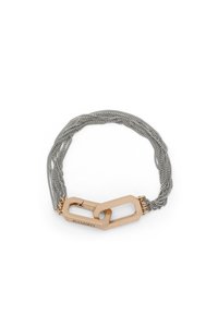 Bracelet en métal composé de plusieurs brins de maille argentée et d'un accent en maillon doré proéminent avec une gravure de marque.