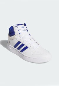 Bijeli tenisice s plavim naglascima. Imaju kožni materijal, visoki dizajn, perforirani vrh i tri karakteristične pruge sa strane.