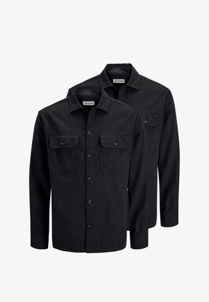 Due camicie nere a maniche lunghe con bottoni, colletto e tasche sul petto, sovrapposte su uno sfondo bianco.