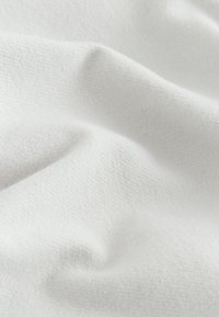 White cotton fabric with a smooth texture, featuring a subtle herringbone pattern and soft folds. Suitable for various textile applications.