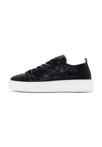 Black leather sneaker with a wrinkled texture, round toe, black laces, and white rubber sole. Features a small loop at the heel.