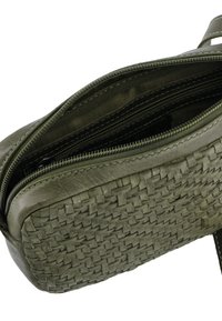 Olivově zelená taška z proplétané kůže se zipovým zapínáním a několika vnitřními přihrádkami. Hladká textura s kontrastním prošitím.