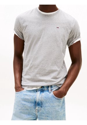 Grijze katoenen T-shirt met opgerolde korte mouwen, voorzien van een klein logo op de borst en gelaagd met een witte ronde hals. Draag met lichtblauwe jeans.
