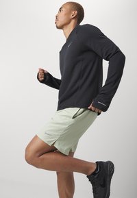 Nike Performance CHALLENGER SHORT - Sports shorts - olive aura/dark stucco/black/silver