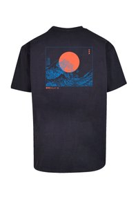Navy katoenen T-shirt met een achterafdruk van golven in blauw met een oranje zon. Tekst in Japanse karakters onder de afbeelding.