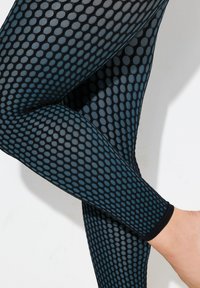 Zwarte mesh legging met een stippenpatroon in variërende tinten blauw, met een aansluitend ontwerp en een gladde textuur.