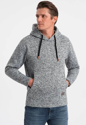 Sudadera gris jaspeada con un bolsillo canguro delantero, cordones negros y una tela texturizada. Presenta puños acanalados y un corte relajado.