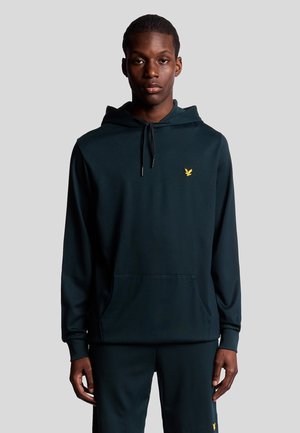 Mörkgrön hoodie i mjukt material, med en kenguruficka, dragsko för huvan och en liten gul logotyp på vänster bröst.