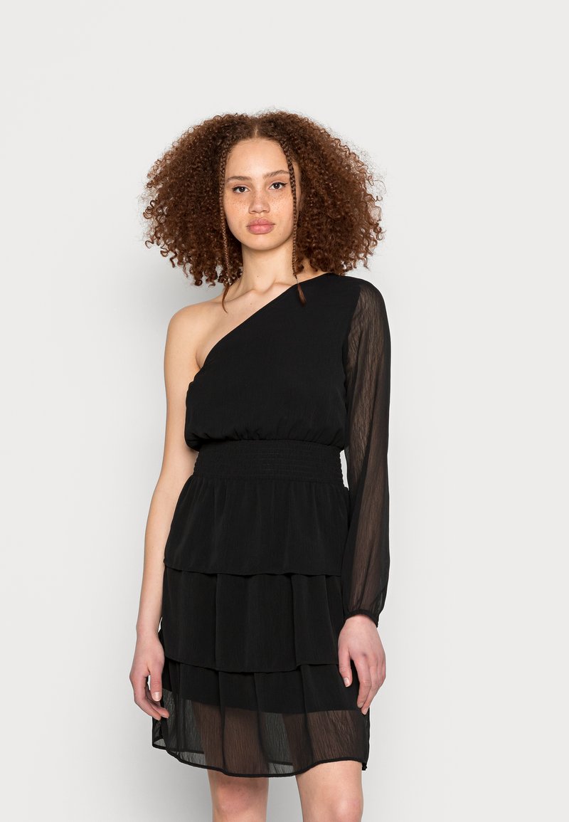 Vestido preto com uma manga longa transparente, cintura franzida e saia com camadas de ruffles. Feito de tecido leve, apresentando um design simples.