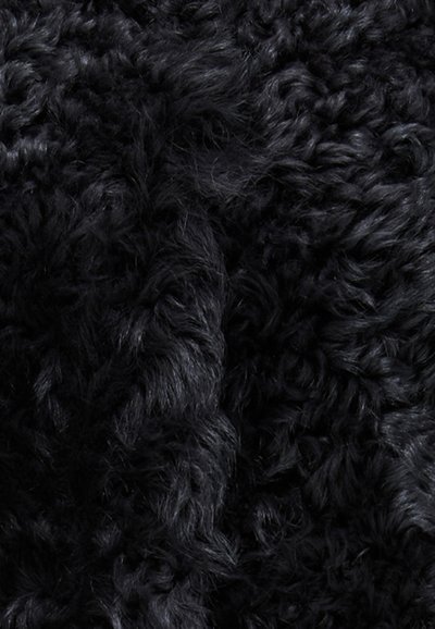 Tessuto in pelliccia nera e con capelli lunghi, caratterizzato da una consistenza spessa e riccia. La superficie appare soffice e morbida, con variazioni nella profondità e nella lucentezza.