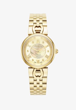 Reloj de tono dorado con caja redonda, correa metálica y esfera de nácar. Presenta números romanos y un logotipo en el centro.