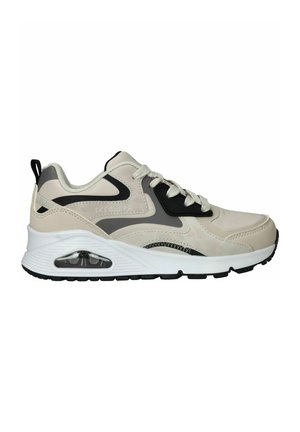 Sneakers met een beige en zwart ontwerp, voorzien van een gladde synthetische bovenkant, vetersluiting en een zichtbare luchtkussen in de zool.