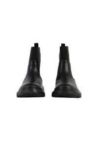 Botas de tobillo de cuero negro con paneles laterales elásticos, puntera redondeada, textura suave y suela de goma plana, diseñadas para poner y quitar fácilmente.