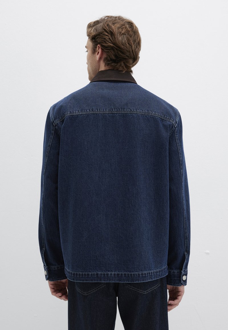 Dunkelblaue Jeansjacke, lockere Passform, mit klassischem Kragen und knöpfbaren Manschetten. Verfügt über kontrastrierende Nähte und eine dezente Textur.