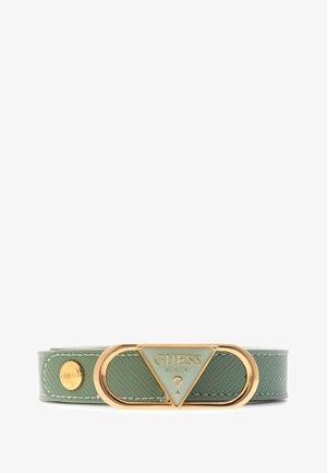 Ceinture en cuir synthétique vert avec une boucle triangulaire dorée, estampillée "GUESS U.S.A.". Surface texturée avec un détail de rivet rond.