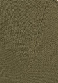 Olivgrüner Strickstoff mit strukturierter Rippenoptik und dezentem Zopfmuster. Die Oberfläche wirkt weich mit einem glatten, gleichmäßigen Gewebe.