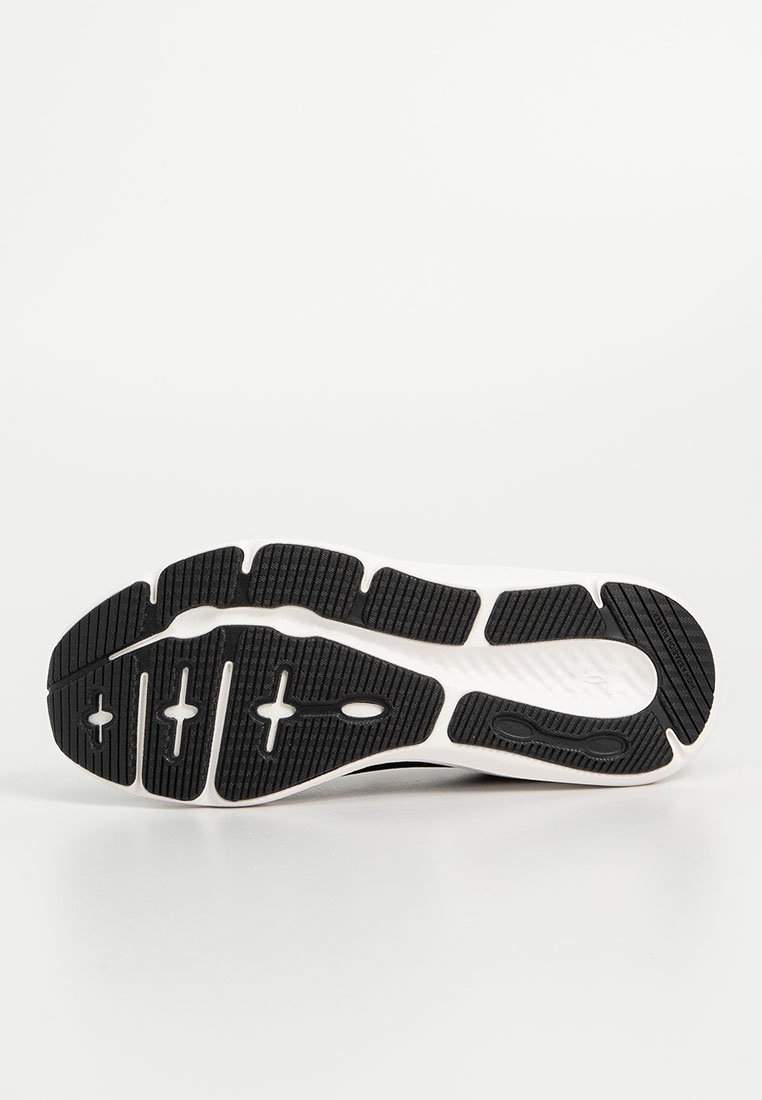 Suela de zapato deportivo en blanco y negro con goma texturizada para un mejor agarre, un diseño curvado y patrones de relieve definidos para ofrecer tracción.