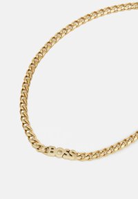 Collana in oro con un design a maglie spesse e la parola "BOSS" in caratteri bold come dettaglio centrale.