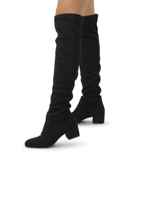 Bottes noires au-dessus du genou en suede doux. Design ajusté avec un bout pointu, un talon carré et une texture floue en haut.