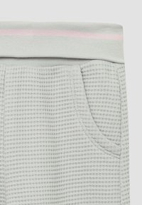 Lichtgrijze shorts met wafelstructuur, voorzien van een elastische tailleband met roze accenten en een zijzak. Zachte stof met een relaxte pasvorm.