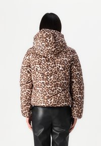 Kurtka puchowa w nadruk w cętki lamparta z kapturem, zamkami błyskawicznymi i pikowanym wzorem. Materiał jest błyszczący, o odcieniach brązu i beżu.