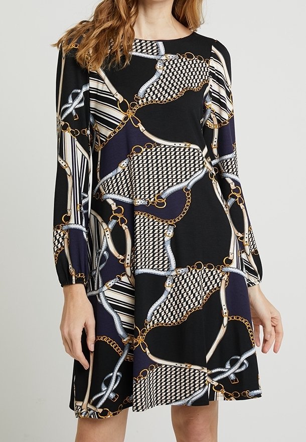 Svart klänning med kedja och mönstertryck med gyllene accenter. Långa ärmar och avslappnad passform. Tillverkad av mjukt, texturerat tyg.