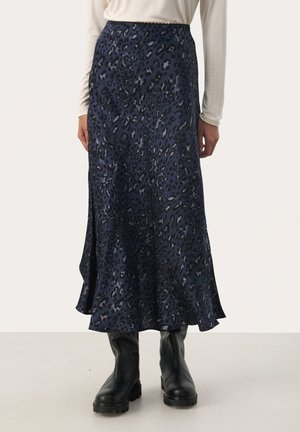 Falda midi de estampado animal en color navy, hecha de tejido suave, con un dobladillo acampanado y una cintura elástica. Combinada con botas negras hasta la rodilla.