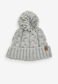 Ljusgrå stickad mössa med en tjock ribbad kant, kabelstickad struktur och en stor pom-pom på toppen. Har en liten logopatch i brunt läder.