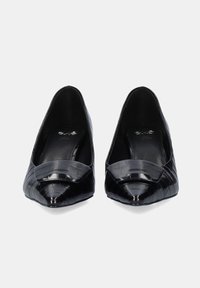 Zapatos de tacón negro, con puntera puntiaguda, textura de cocodrilo, acabado suave y un lazo en la parte delantera; diseñados sin tacones.