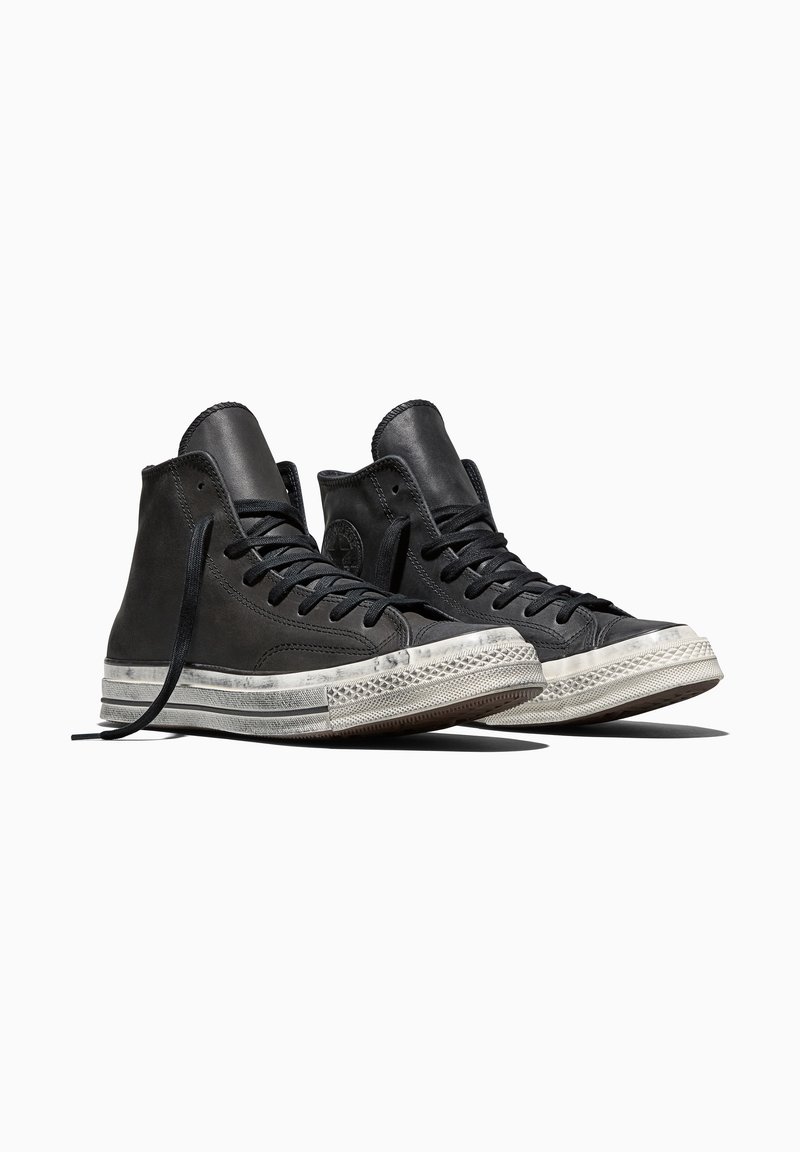 Pair of black high-top sneakers with white rubber soles and laces, positioned side by side on a white background.