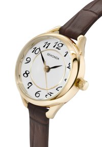 Montre analogique dorée avec un cadran blanc, des index noirs et un bracelet en cuir marron. Dispose d'une couronne sur le côté droit pour les réglages.