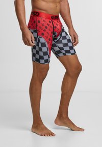 Caleçons boxers pour hommes rouges et noirs avec un motif à carreaux et une ceinture logo, fabriqués dans un matériau lisse et extensible.