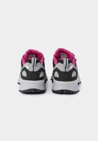 Paire de chaussures de sport grises et noires avec doublure intérieure rose, vue de dos sur fond blanc.