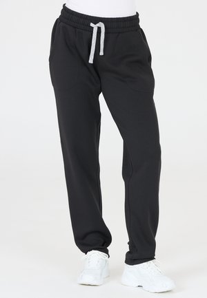 Pantalons de survêtement noirs en tissu doux, dotés d'une taille élastique avec cordon de serrage ajustable, de poches latérales et d'ouvertures de jambes fuselées.